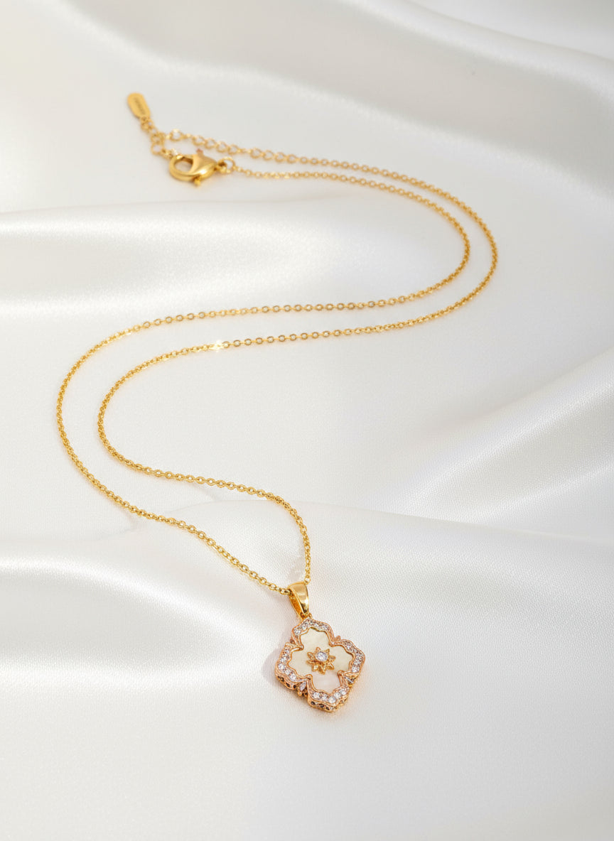 Gold necklace with a floral pendant on a white background