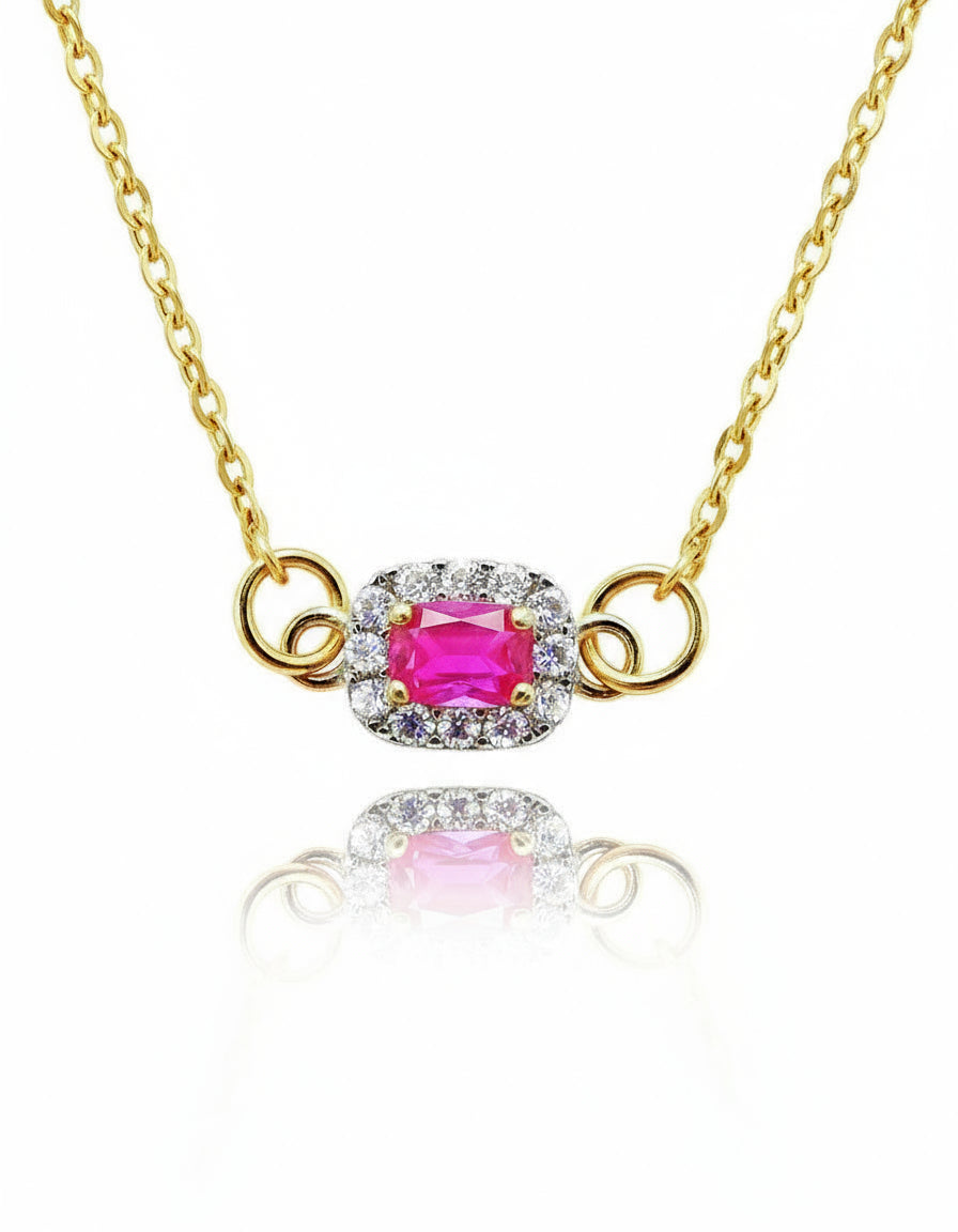Gold necklace with a pink gemstone on a white background
