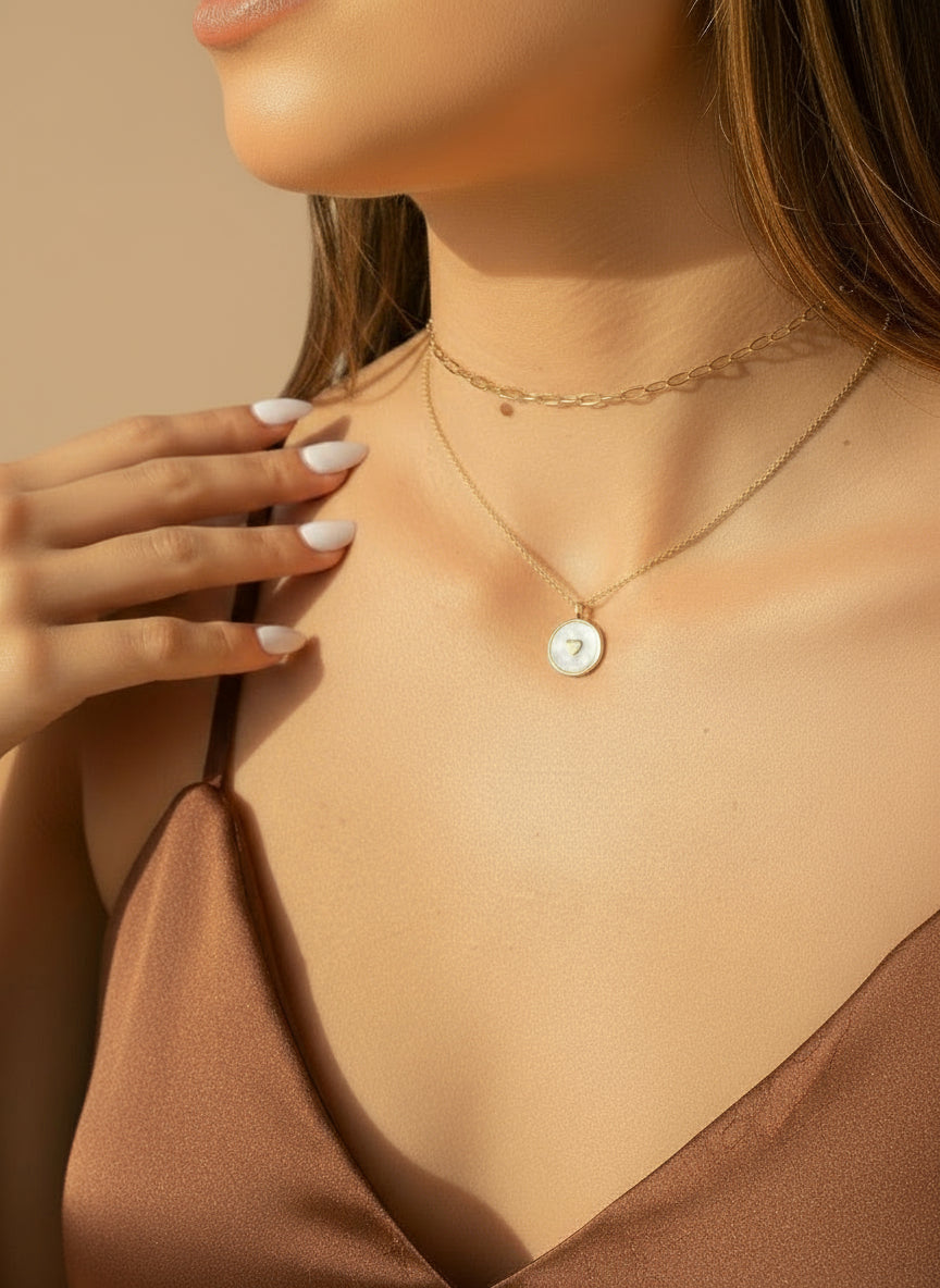 Close-up of a person wearing a delicate necklace with a heart pendant.