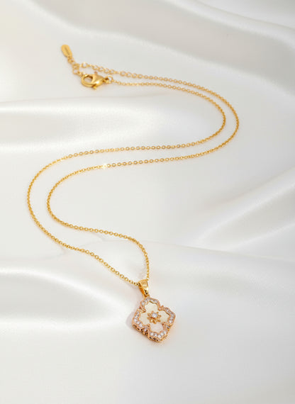 Gold necklace with a floral pendant on a white background