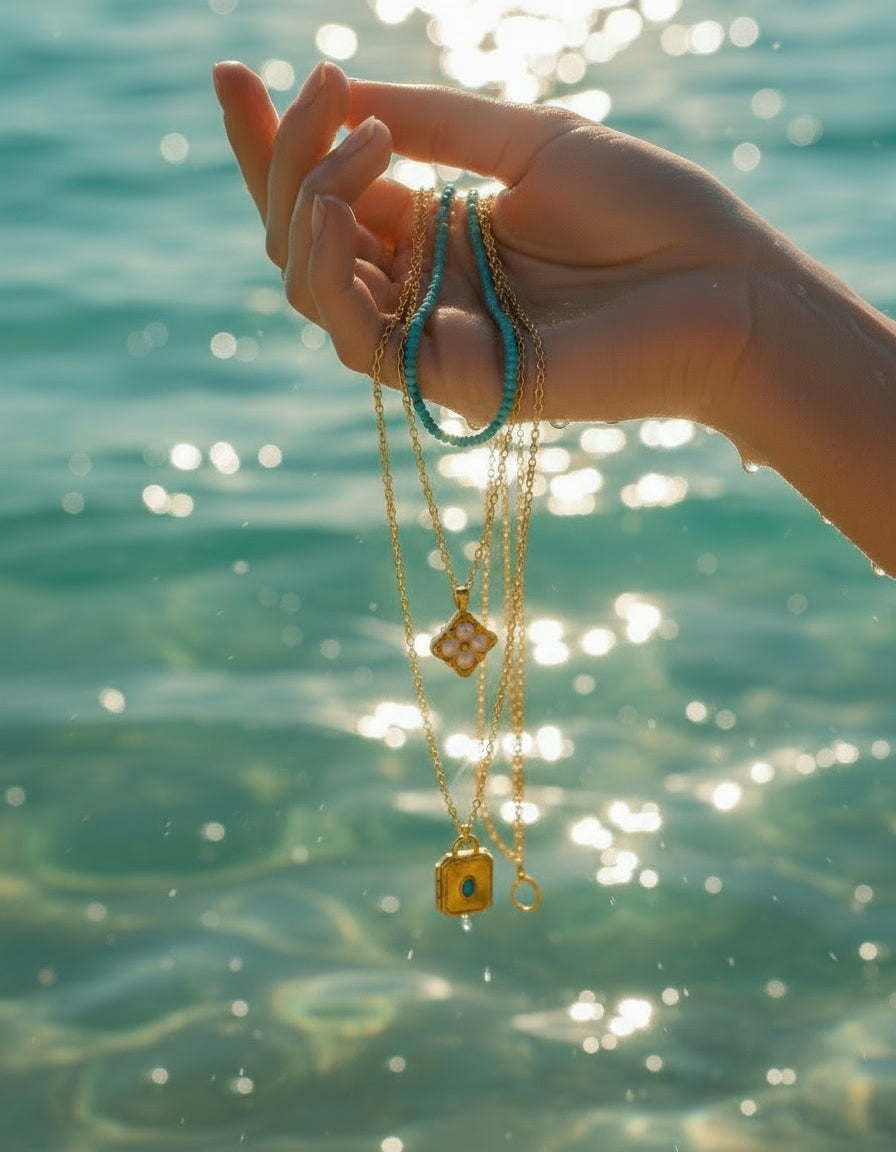 Two gold necklaces with pendants on a white background