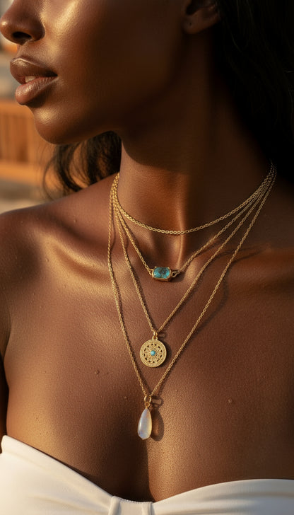 Close-up of a woman wearing gold necklaces with pendants.