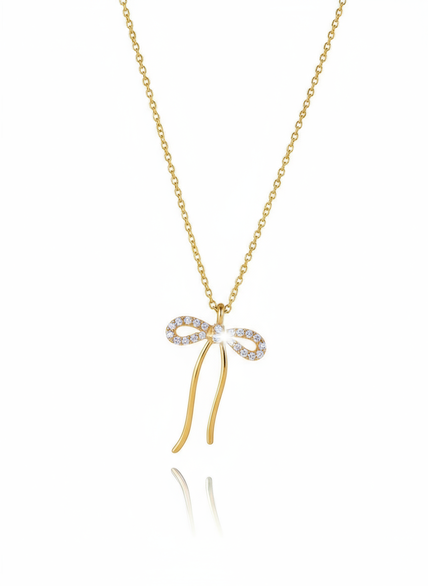 Gold necklace with a bow-shaped pendant on a white background