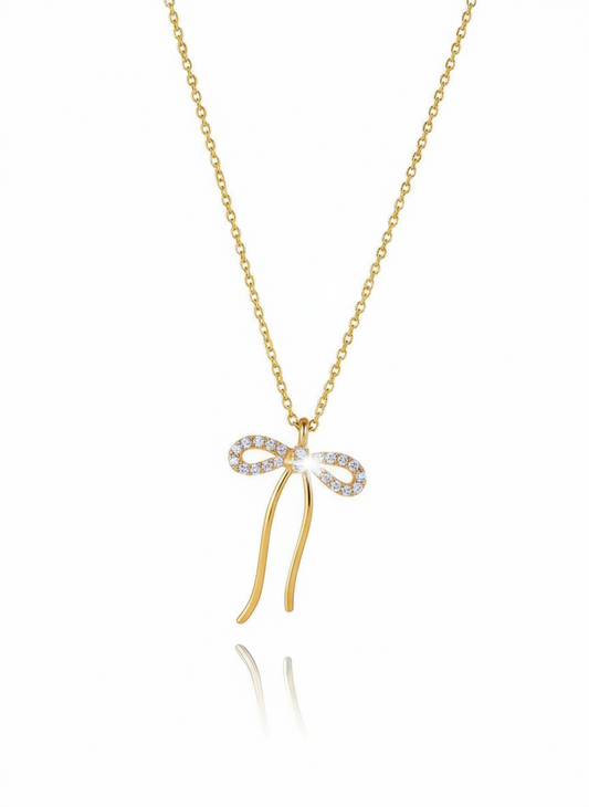 Gold necklace with a bow-shaped pendant on a white background