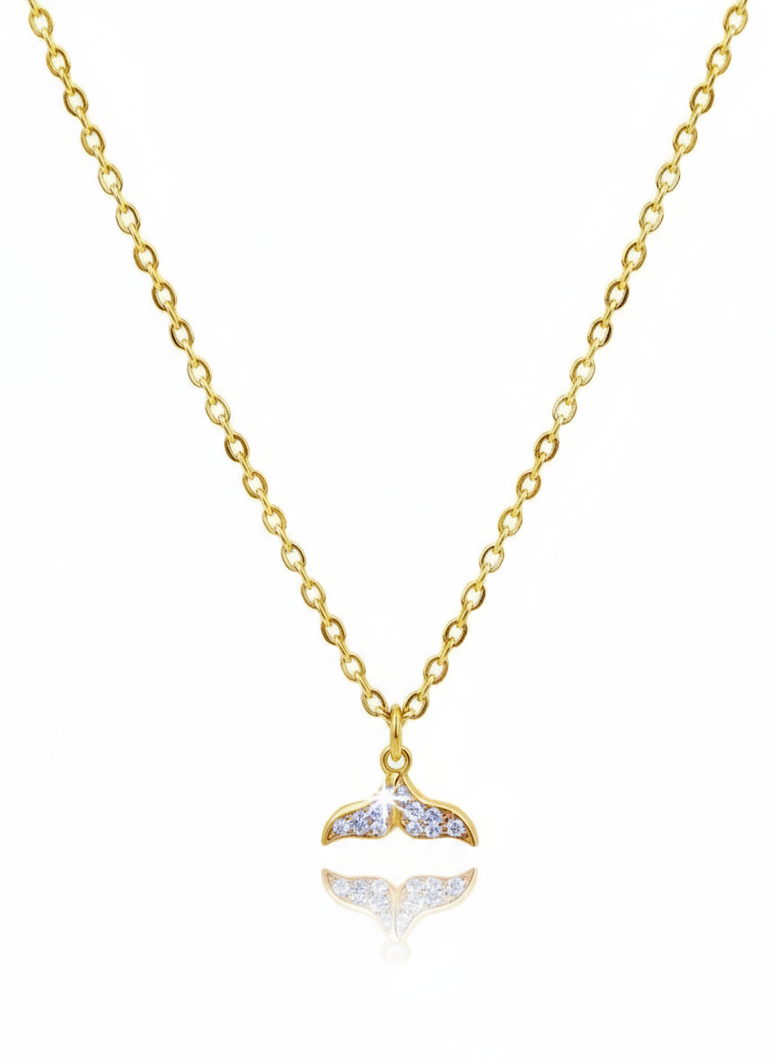 Gold necklace with a whale tail pendant on a white background