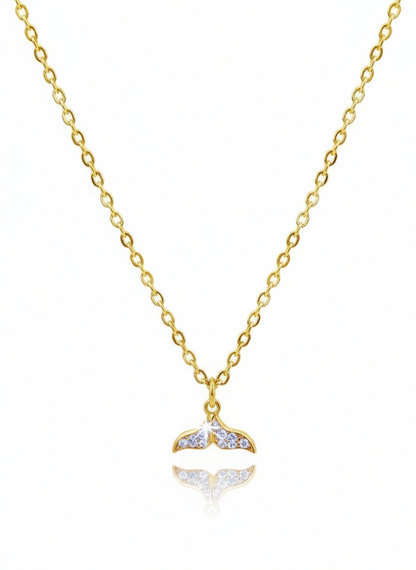 Gold necklace with a whale tail pendant on a white background