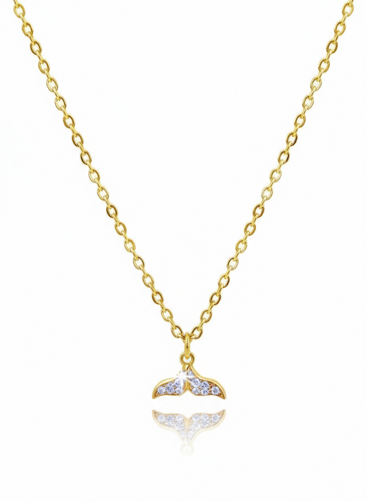Gold necklace with a whale tail pendant on a white background