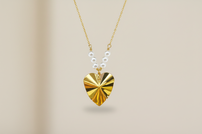 Gold heart-shaped pendant necklace on a beige background